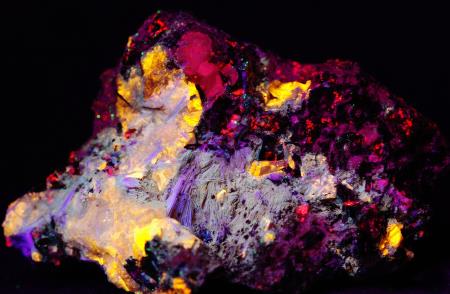 Fluorescent Xonotlite crystals, roeblingite, clinohedrite under shortwave UV light.