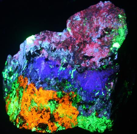 Fluorescent margarosanite, feldspar, hardystonite, clinohedrite, willemite under shortwave UV light. Fluorescent margarosanite, feldspar, hardystonite, clinohedrite, willemite under shortwave UV light.