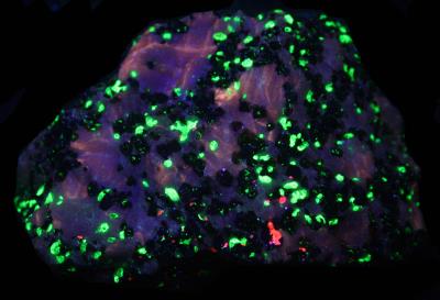 Yellow Fluorescent calcite, willemite, franklinite and minor sphalerite, Sterling Hill Mine, NJ. under shortwave UV Light