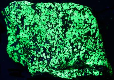 Red willemite, calcite and franklinite, Sterling Hill Mine under shortwave UV Light