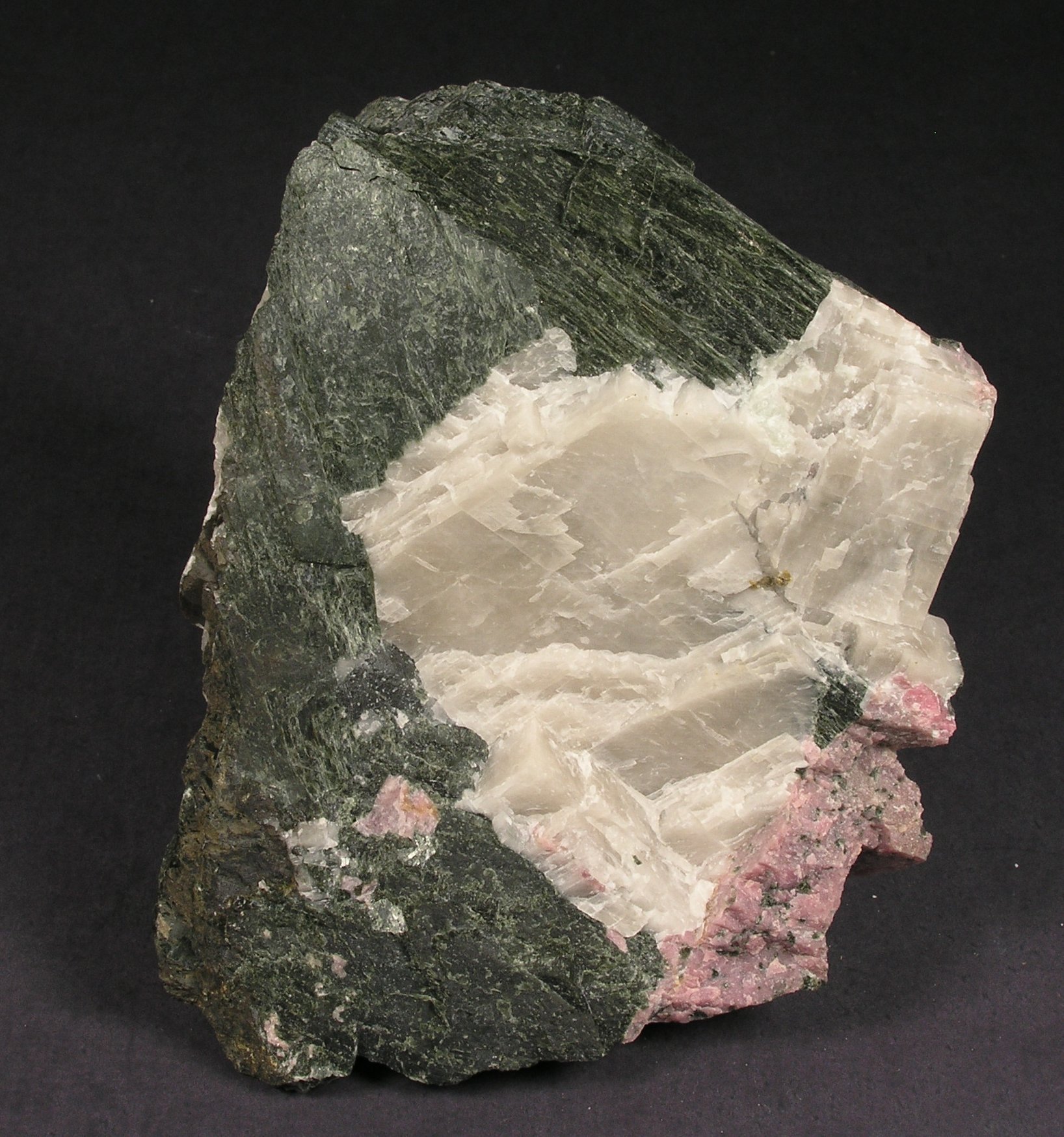 Massive, dark green, coarse-grained actinolite with pink rhodonite and white calcite