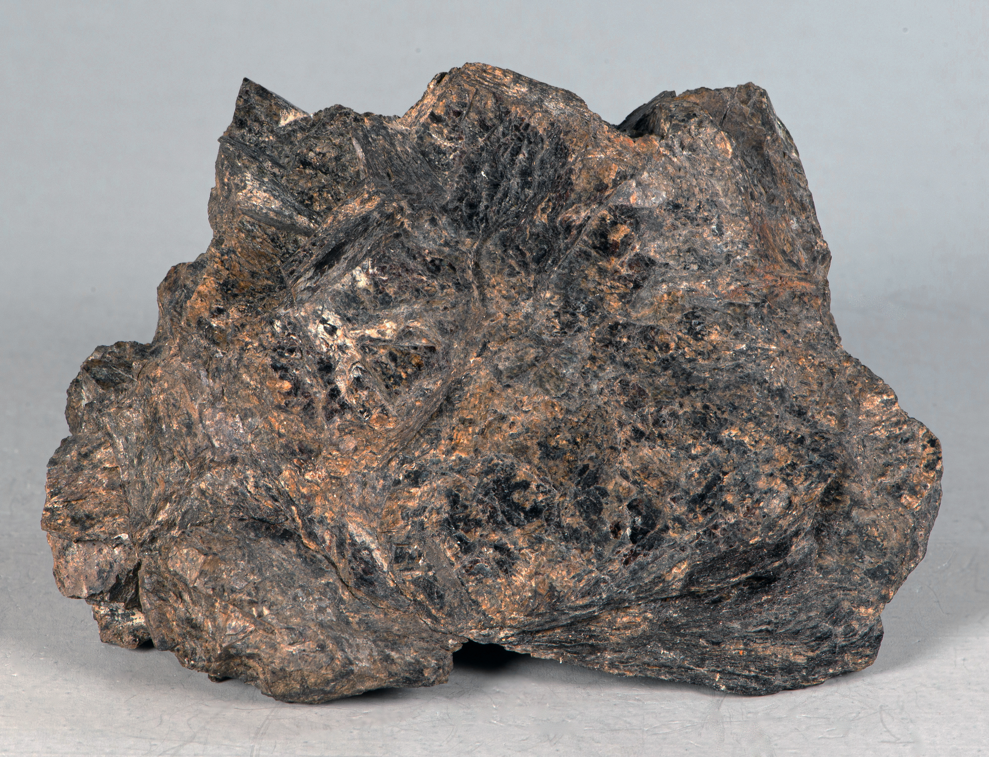 Coarse-grained, intergrown, platy masses of dark brown bannisterite