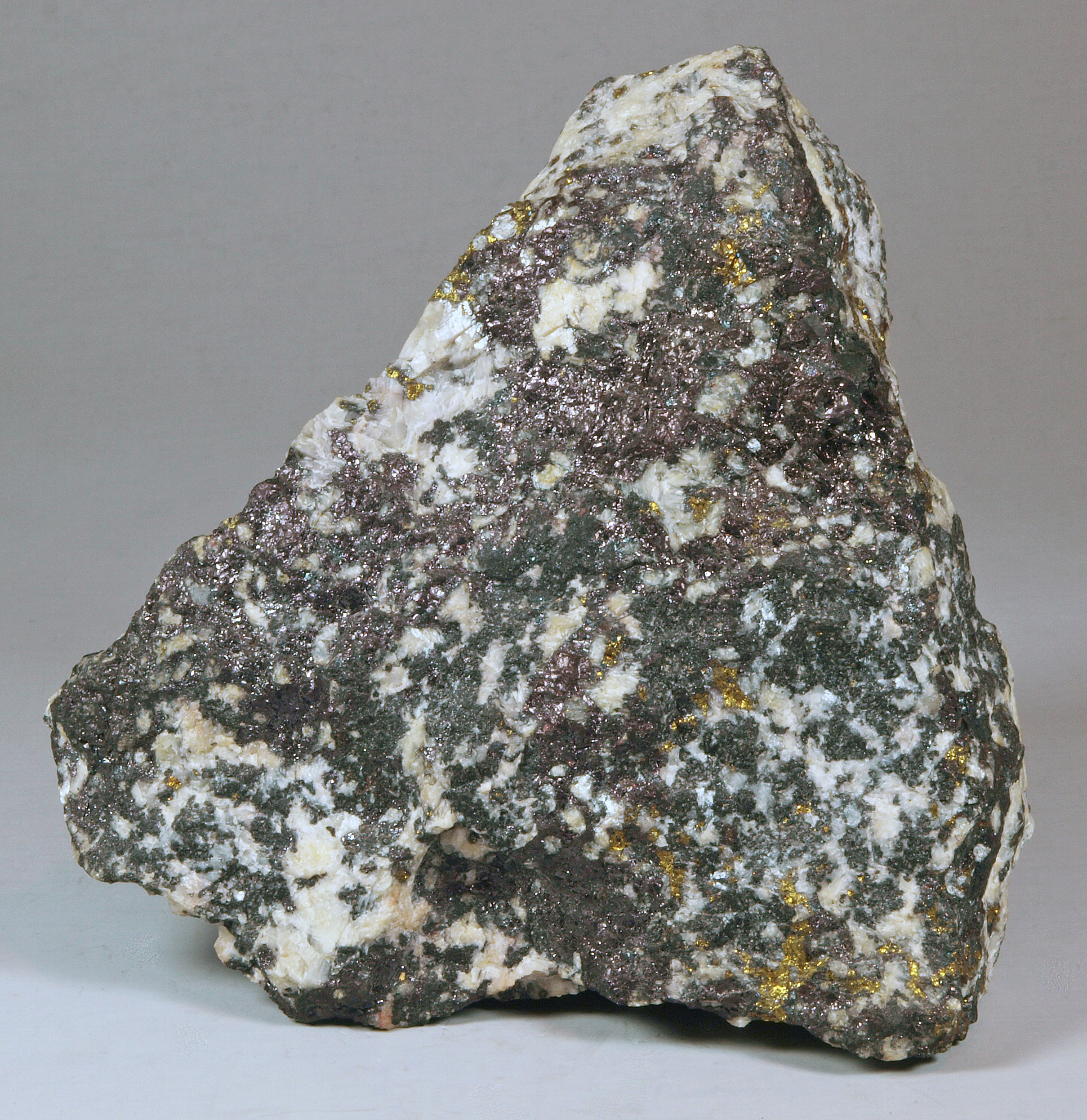 Dark violet blebs of bornite, gold chalcopyrite, white calcite, dark green to brownish-green pyroxene, Sterling mine, Ogdensburg NJ